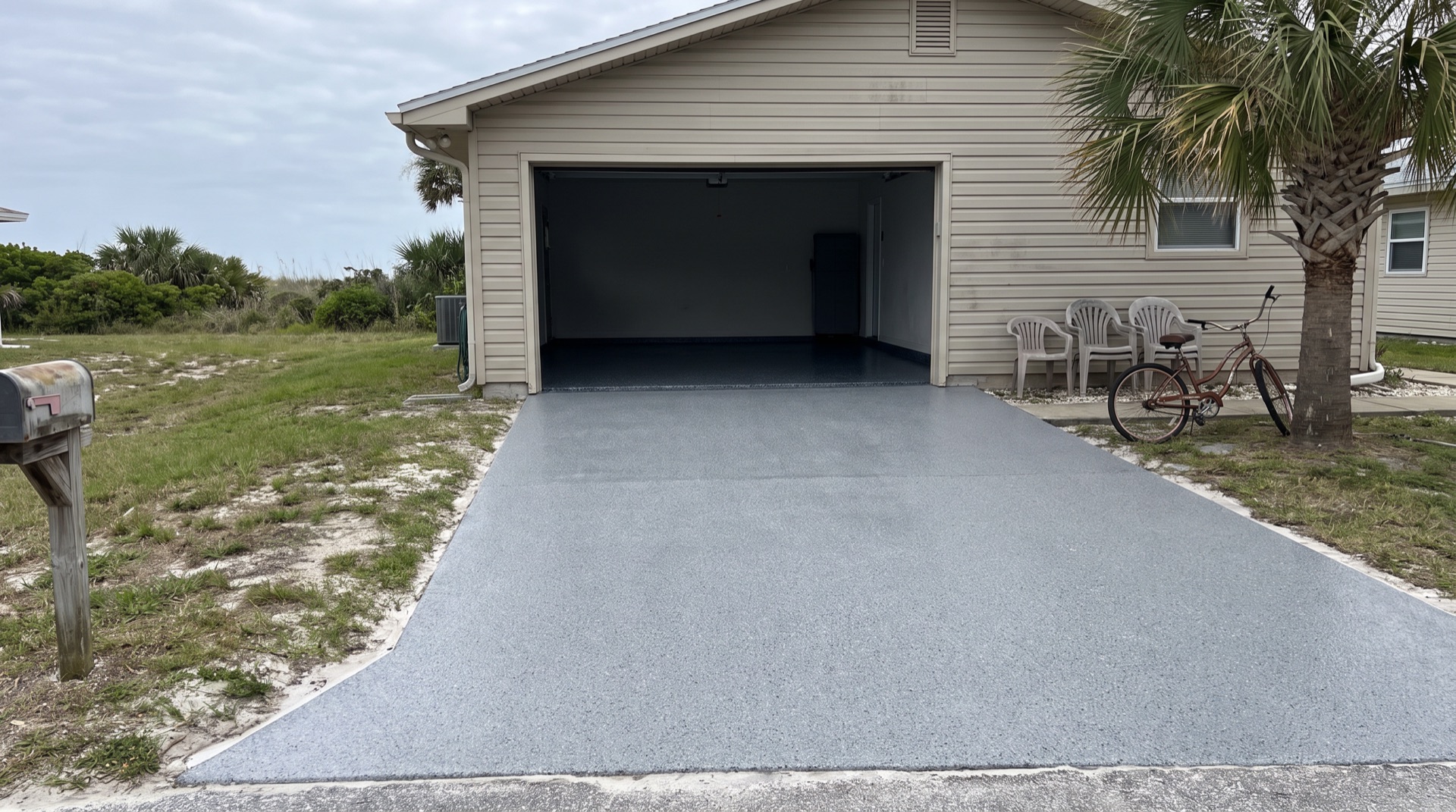 Freshly coated concrete driveway and open garage with a glossy flake floor at a Jacksonville Beach home